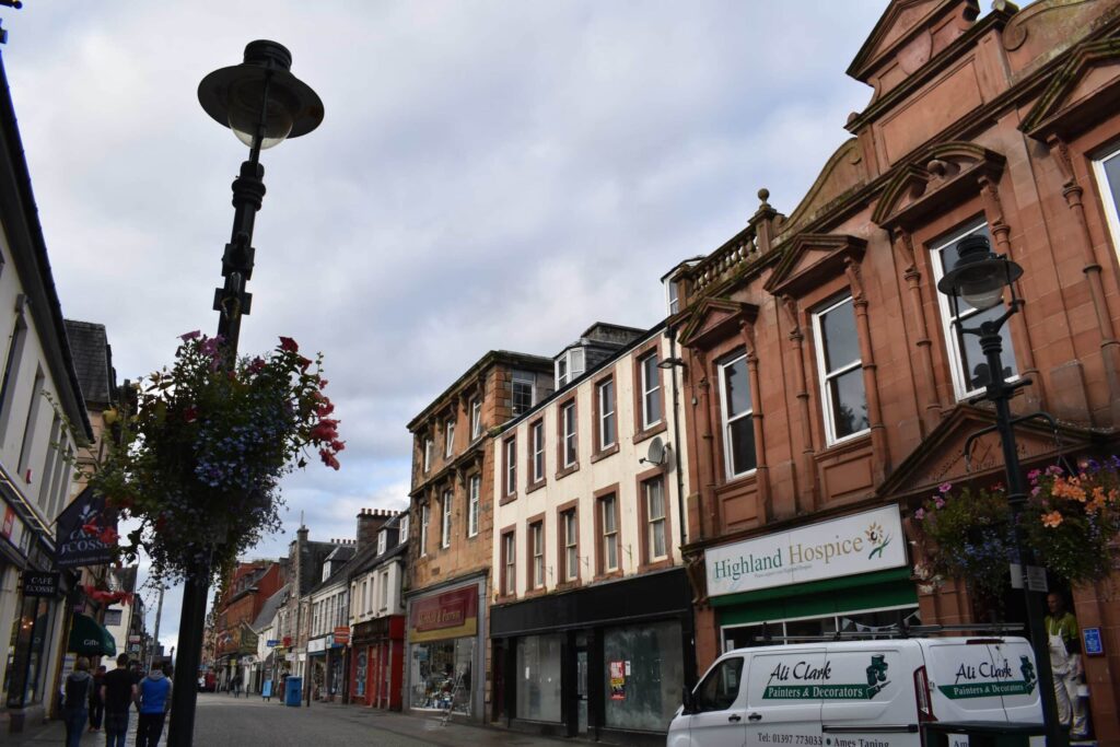 Shops and stone buildings along a street in central Fort William