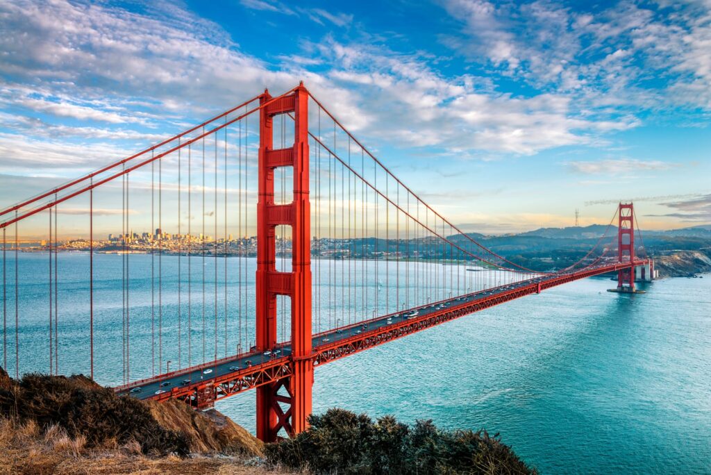Golden Gate Bridge stretching across San Francisco Bay beneath a cloudy sky