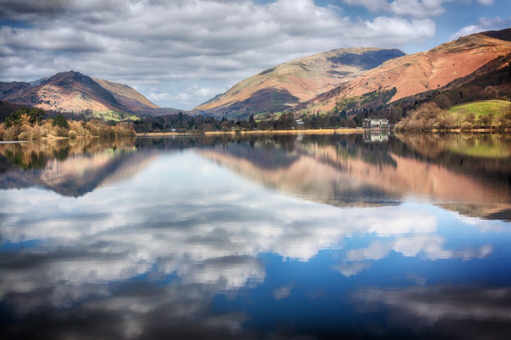 Autumn hills and clouds reflected in the still water of Grasmere