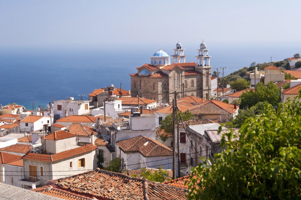 Church and tiled rooftops in Marathokampos with the sea in the background