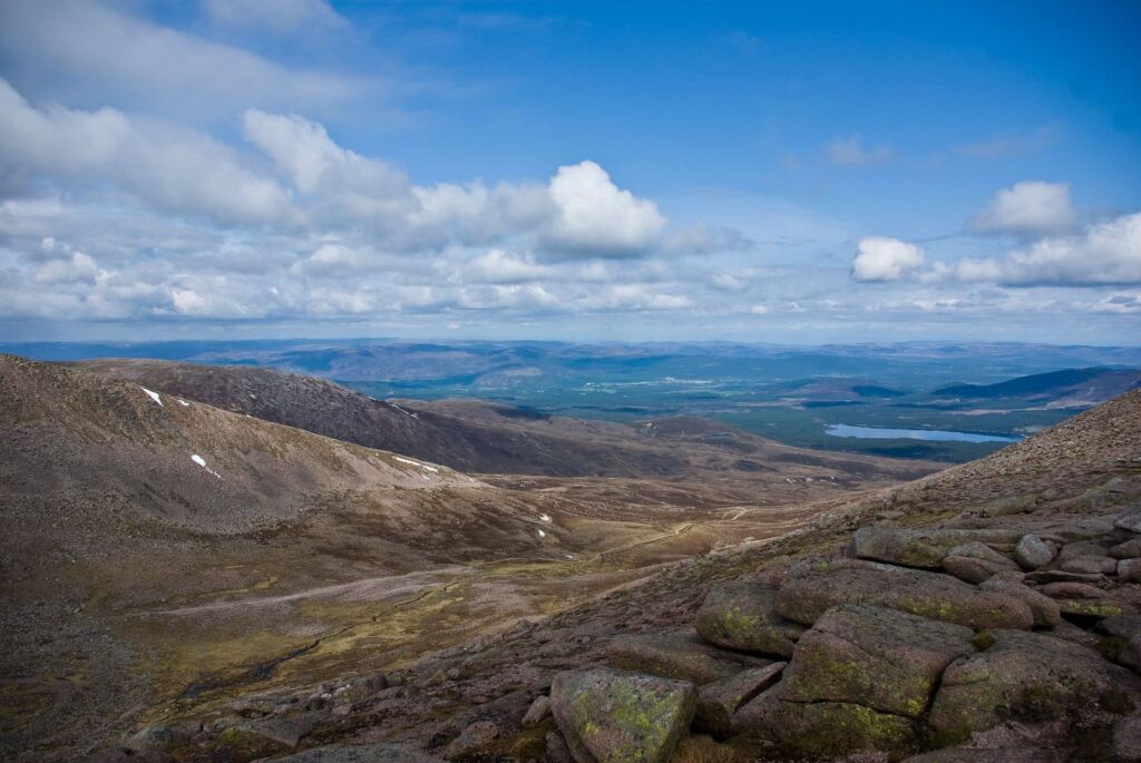 Rocky mountain slopes with woodland and a loch in the distance near Aviemore