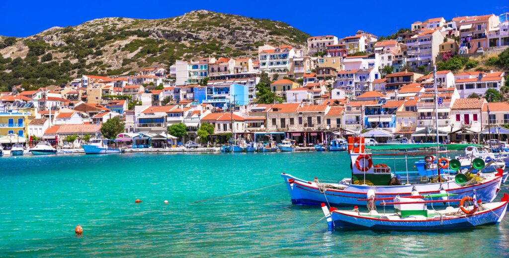 Colourful fishing boats and houses along the waterfront in Pythagorion