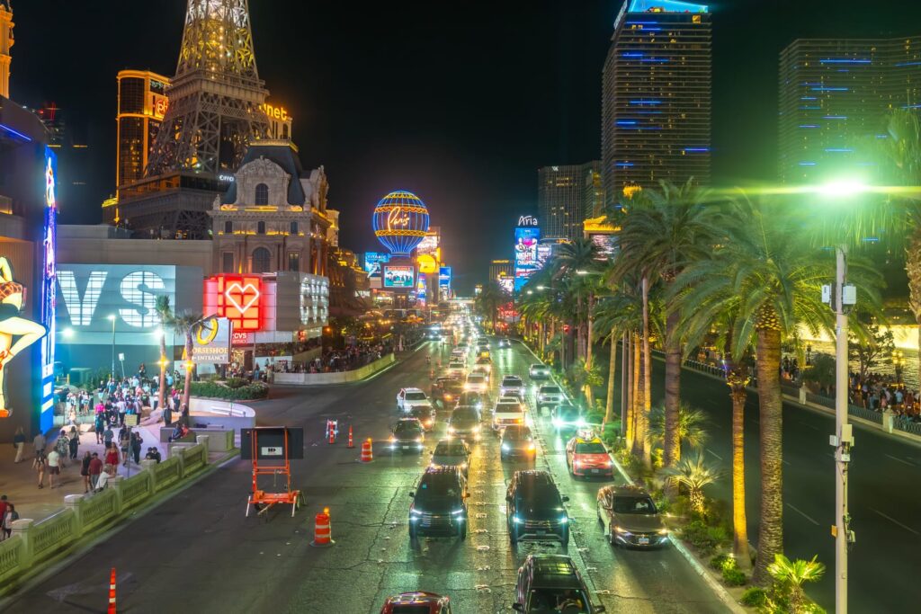 Traffic, palm trees and illuminated hotels along the Las Vegas Strip at night