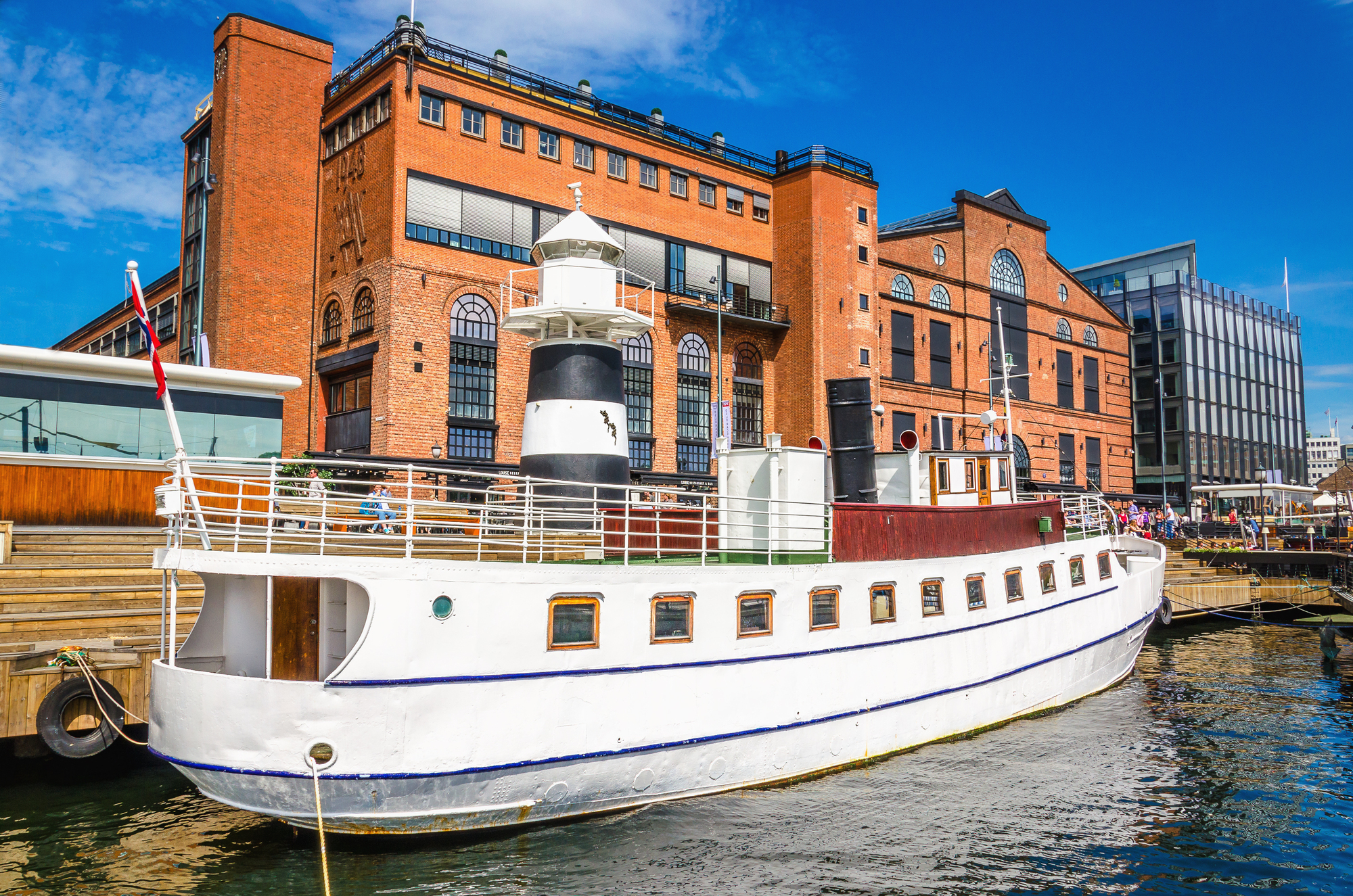Aker Brygge in Oslo with a white yacht in the harbour