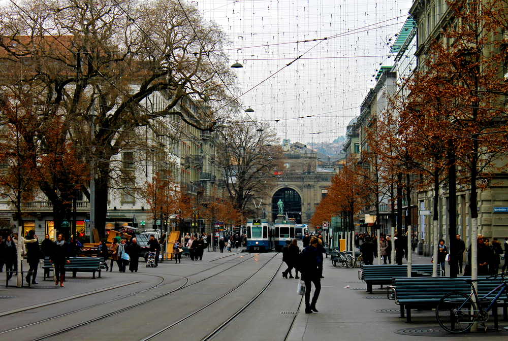 Bahnhofstrasse in Zurich with tram tracks and pedestrians and the main station at the end of the street