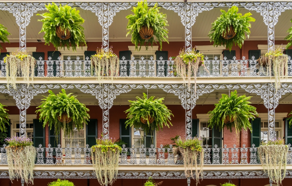 House with wrought-iron balconies and hanging flower baskets on Royal Street in the French Quarter