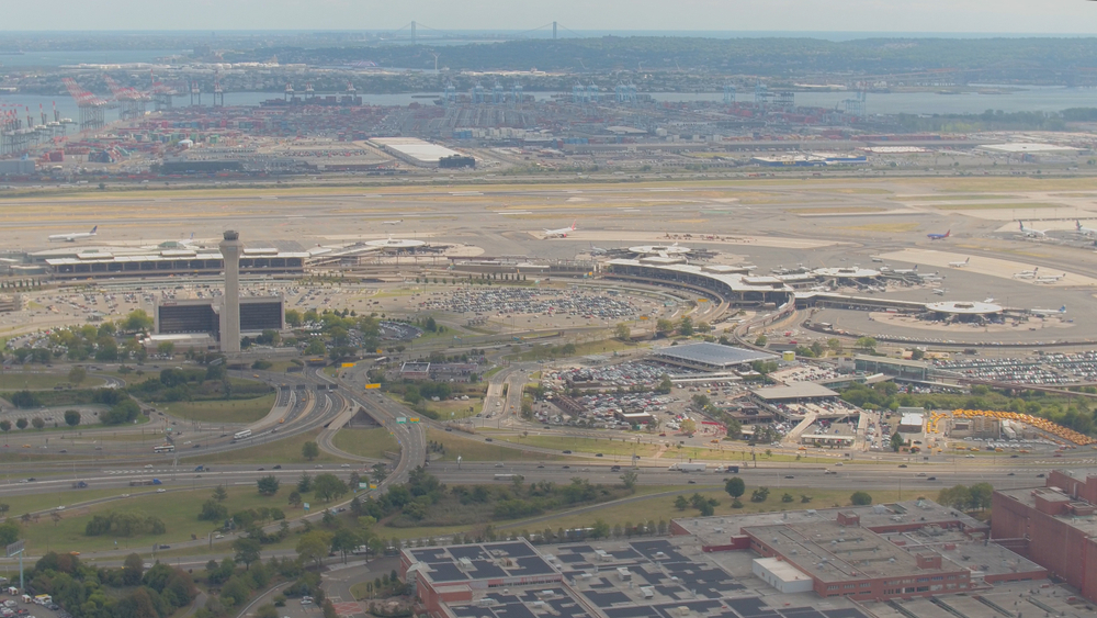 Road sign for Newark Liberty International Airport in front of the airport's control tower