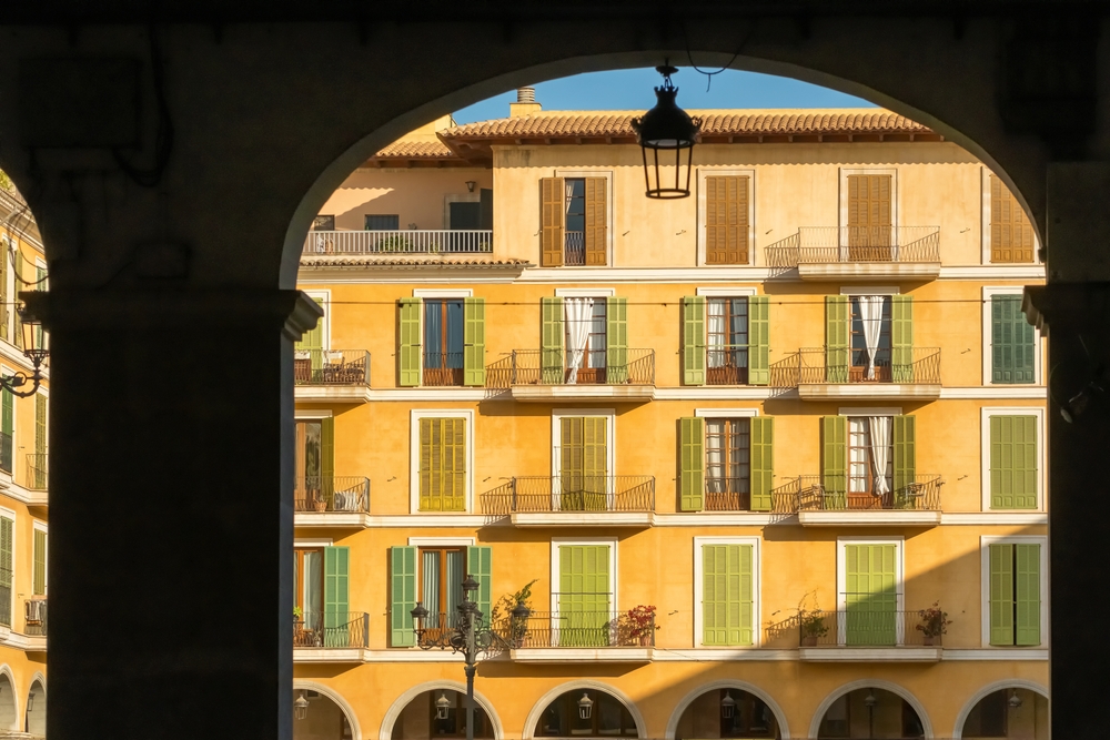 Plaza Mayor in the Old Town of Palma de Mallorca seen through a stone arch