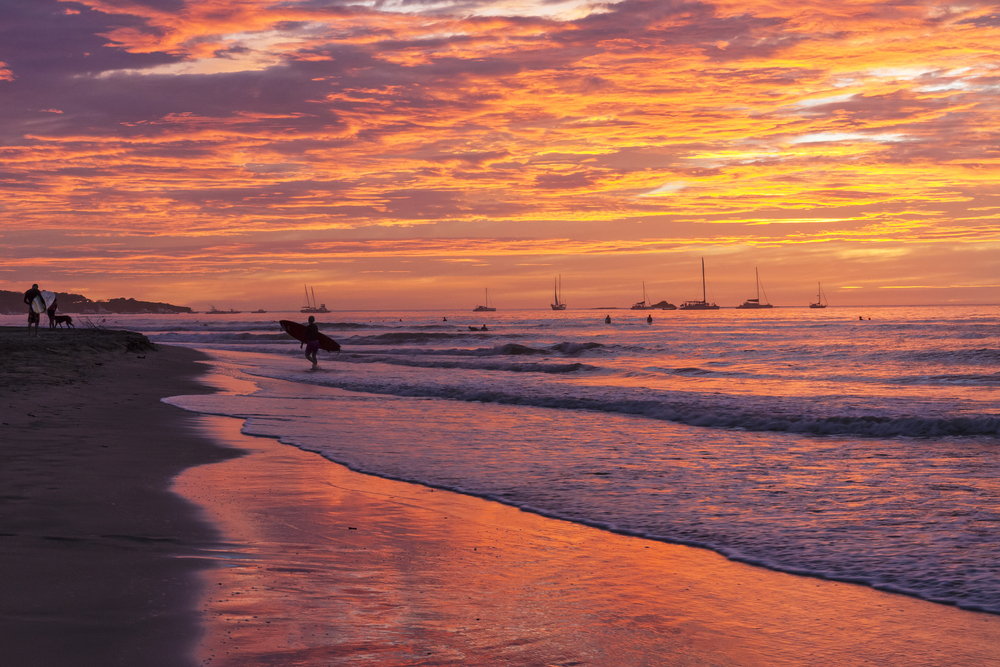 Surfer on the beach in Tamarindo in Guanacaste at sunset