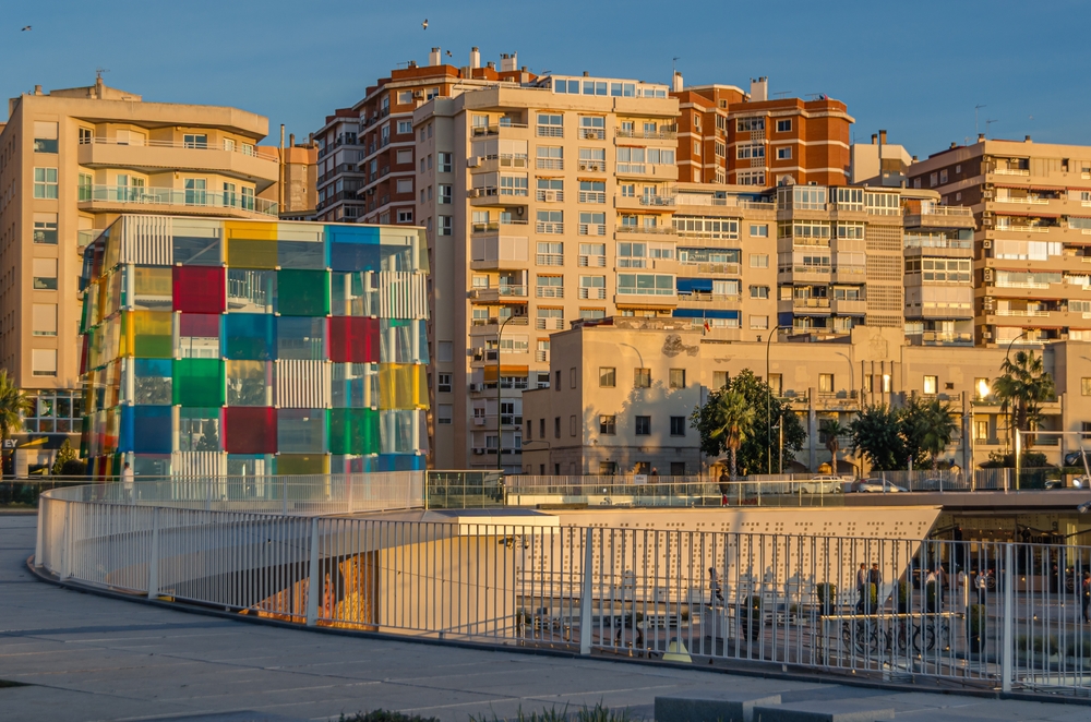 The Muelle Uno promenade in Malaga with the El Cubo glass cube of the Centre Pompidou in the background