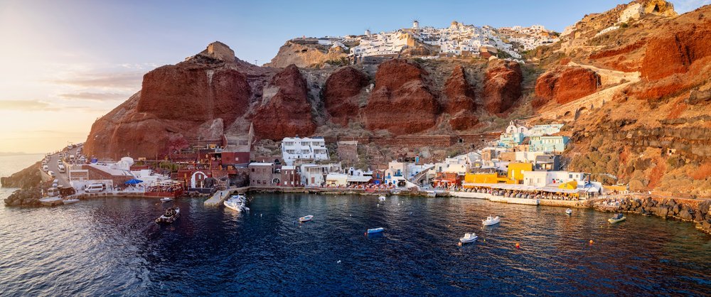 Ammoudi Bay with restaurants and fishing boats in the sunset light