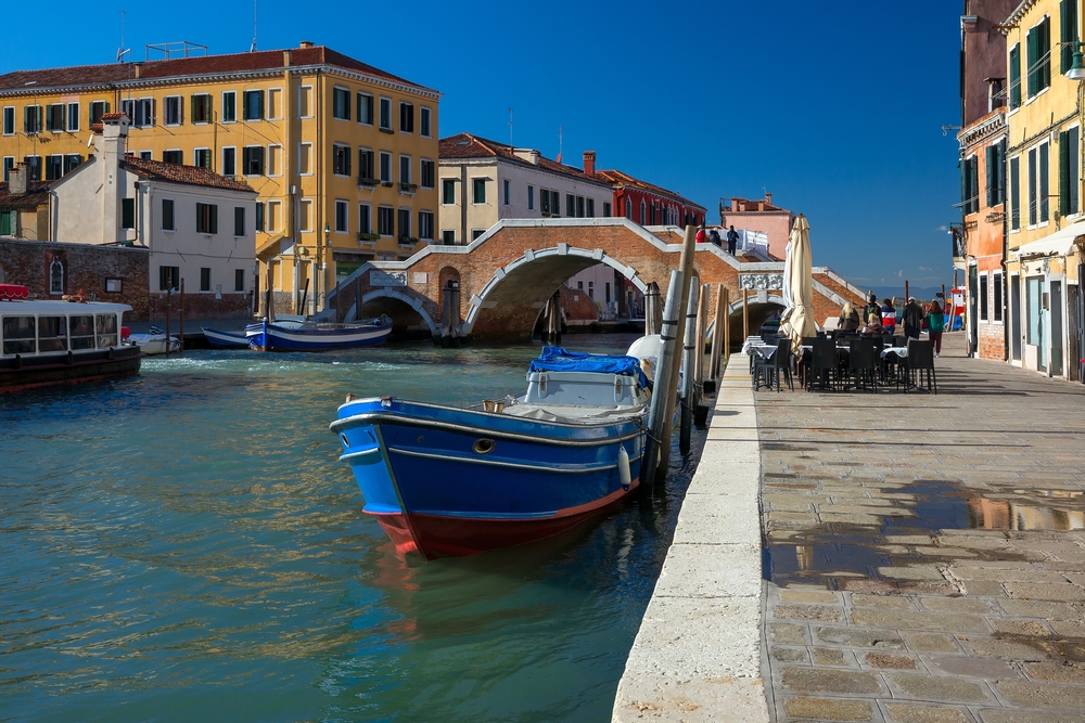 A canal in Cannaregio in Venice with the Ponte dei Tre Archi bridge