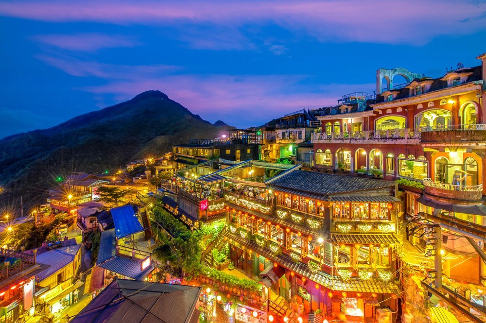 Where to Stay in Taiwan? The 7 Best Areas & Places to Stay 4 Jiufen in the evening with lights in the houses and teahouses on the mountainside above the sea