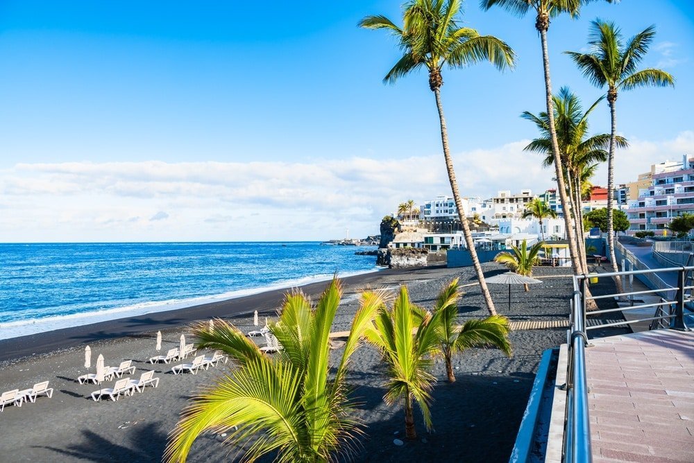The palm-lined promenade and black-sand beach in Puerto Naos on La Palma