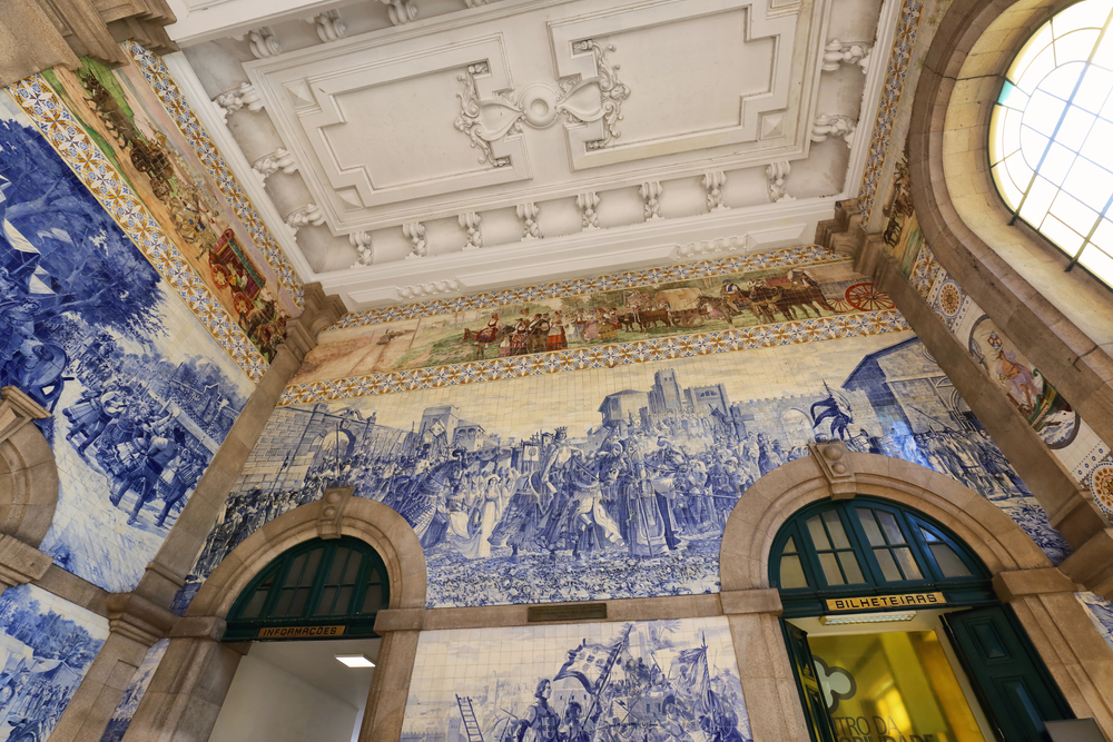 17 Best Things to Do in Porto: Sights, Prices & Tips 9 Blue and white azulejo tiles on the walls of the main hall at São Bento station in Porto