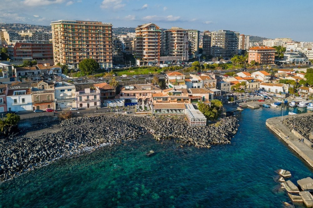 The small harbour and black lava beach at San Giovanni li Cuti in Catania