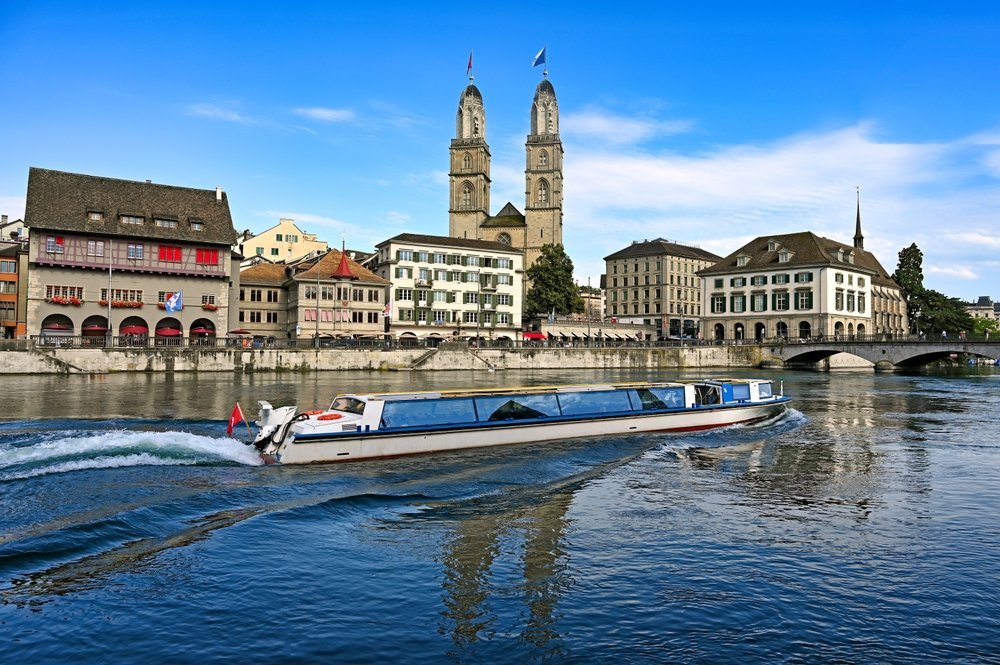 Tourist boat sailing on the Limmat in Zürich with the Grossmünster in the background