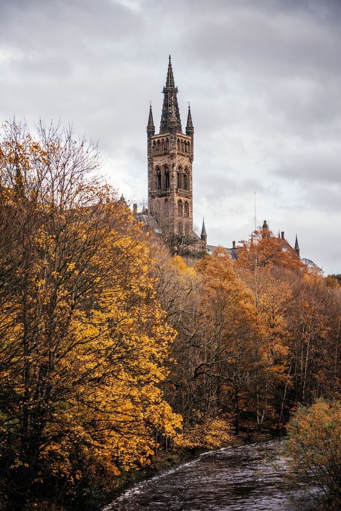 The University of Glasgow tower above the trees by the River Kelvin