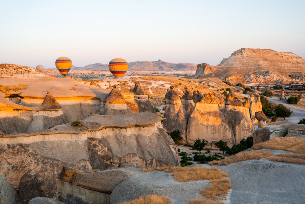Hot-air balloons floating over the rock formations in Cappadocia at sunrise