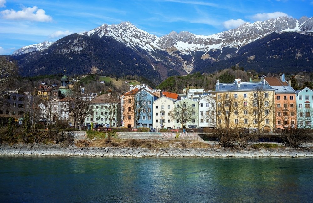 Where to stay in Innsbruck: the colourful houses along the River Inn with the Nordkette in the background