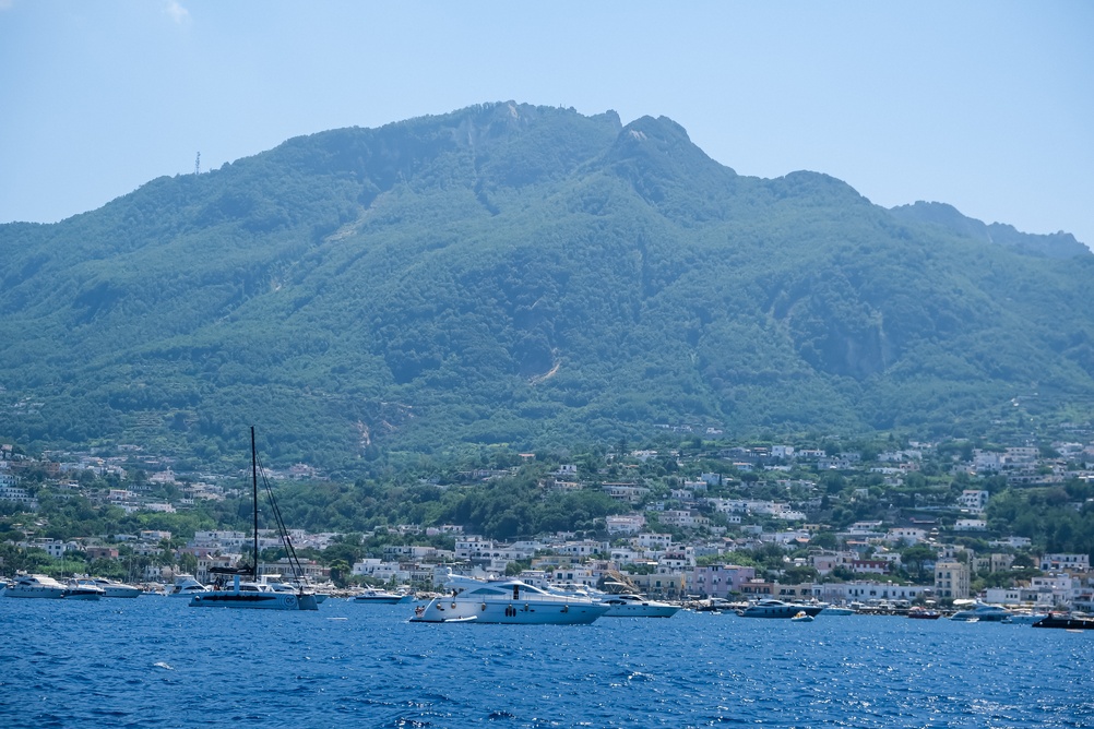 Mount Epomeo and a harbour town on Ischia with boats at anchor in the foreground