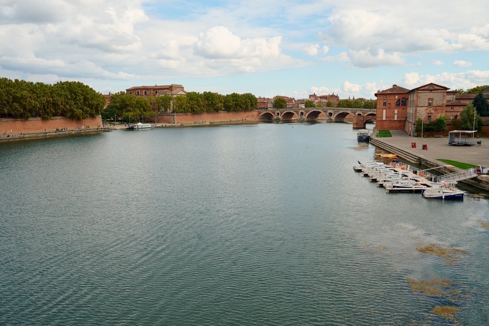 The River Garonne and the Pont Neuf bridge in Toulouse, with the pink brick houses along the quayside