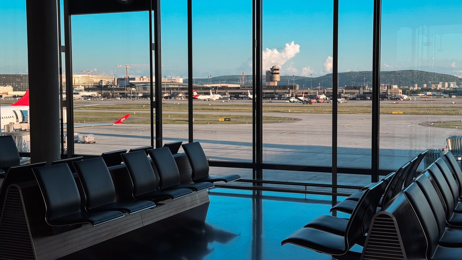 Terminalen i Zürich Lufthavn med fly og bjerge